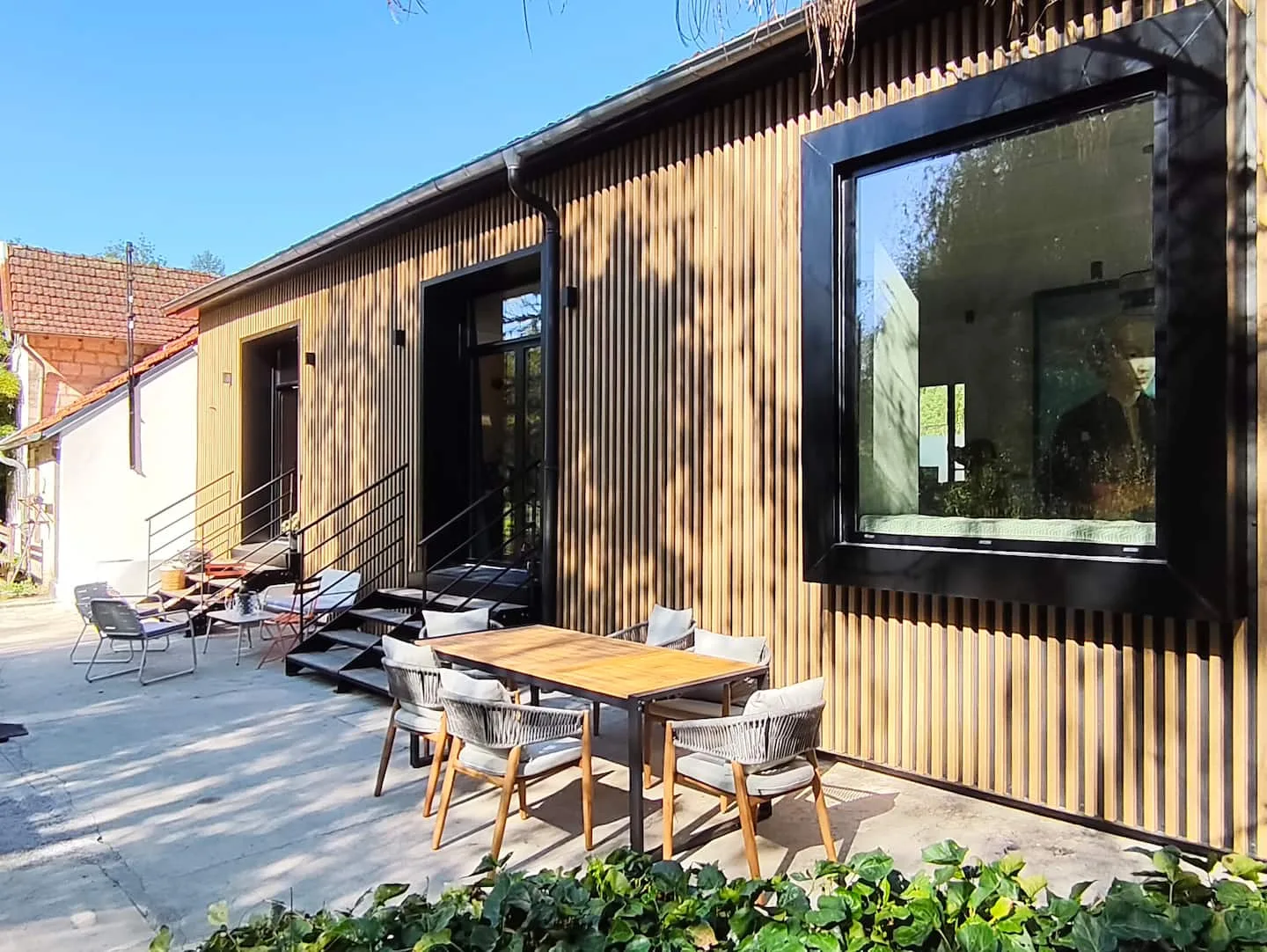 Timber facade and terrace at Le 10, by the pond